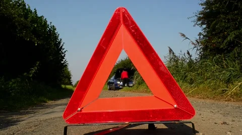 Hazard warning triangle by man repairing broken down car on country road uk Stock Footage 67535190