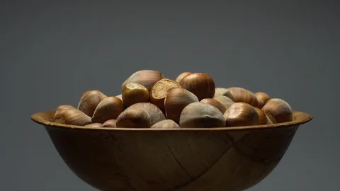 Hazel nuts in nutshell. Rotation. Closeup.  Walnuts in a bowl. Grey background. Stock Footage 101545397