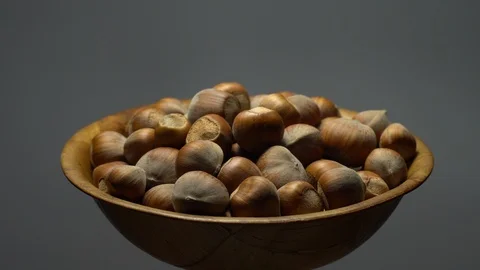 Hazel nuts in nutshell. Rotation. Closeup.  Walnuts in a bowl. Grey background. Stock Footage 101551321
