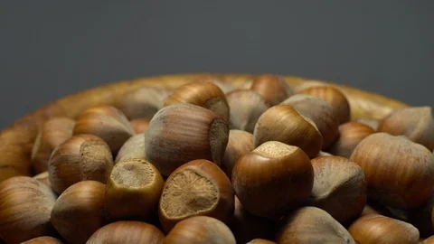 Hazel nuts in nutshell. Rotation. Closeup.  Walnuts in a bowl. Grey background. Stock Footage 101551558