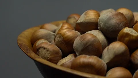 Hazel nuts in nutshell. Rotation. Closeup.  Walnuts in a bowl. Grey background. Stock Footage 101552466