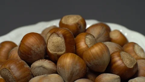 Hazel nuts in nutshell. Rotation. Closeup.  Walnuts in a bowl. Grey background. Stock Footage 101555425