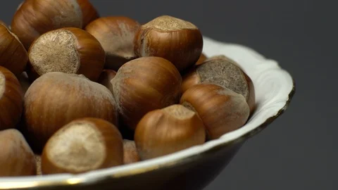 Hazel nuts in nutshell. Rotation. Closeup.  Walnuts in a bowl. Grey background. Stock Footage 101555782