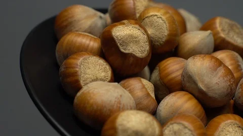 Hazel nuts in nutshell. Rotation. Closeup.  Walnuts in a bowl. Grey background. Stock Footage 101556350