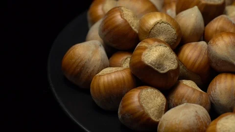 Hazel nuts in nutshell. Rotation. Closeup. Selective focus. Black background. Stock Footage 101556576