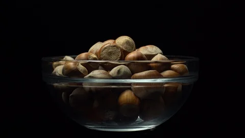 Hazel nuts in nutshell. Rotation. Closeup. Selective focus. Black background. Stock Footage 101556604