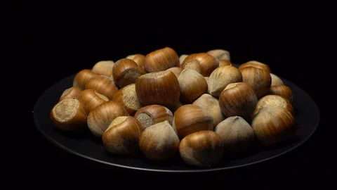 Hazel nuts in nutshell. Rotation. Closeup. Selective focus. Black background. Stock Footage 101556639