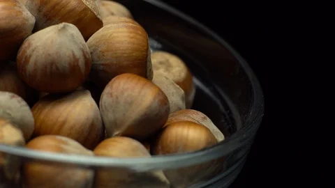 Hazel nuts in nutshell. Rotation. Closeup. Selective focus. Black background. Stock Footage 101587371