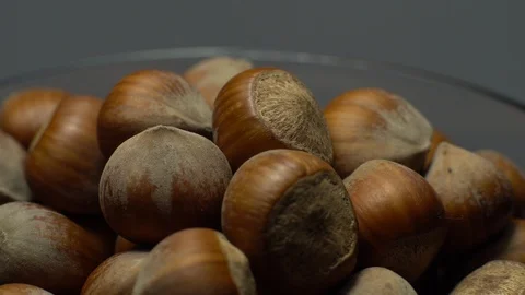 Hazel nuts in nutshell. Rotation. Closeup.  Walnuts in a bowl. Grey background. Stock Footage 101587958