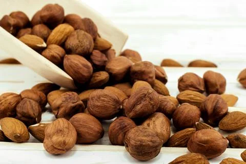 Hazelnut and almonds close-up on a wooden background. Nuts in a wooden scoop Stock Photos