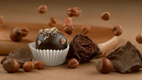Hazelnut Chocolate truffle with ingredients falling in slow motion.  Shot with Stock Footage 130355132