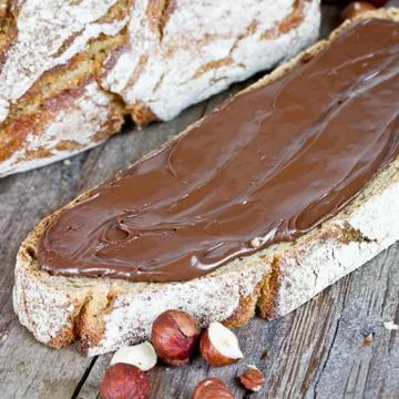 Hazelnut cream on bread Stock Photos