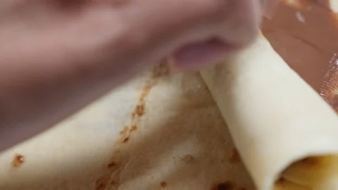 Hazelnut creme spread over pancake and rolling slow motion Stock Footage 72183692