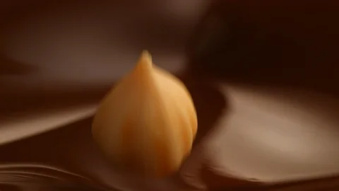 Hazelnut fall into chocolate bath10 Stock-Footage 94565358