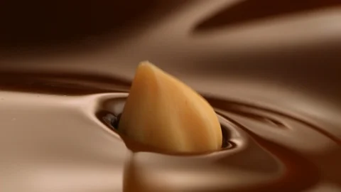 Hazelnut fall into chocolate bath13 Stock-Footage 94566671