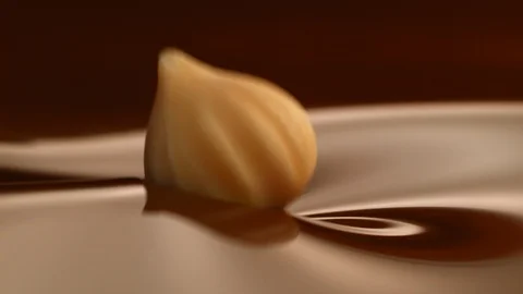 Hazelnut fall into chocolate bath3 Stockbeeldmateriaal 94563342