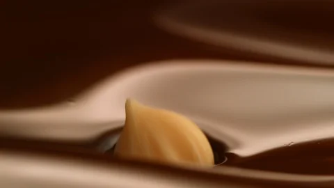 Hazelnut fall into chocolate bath9 Stock-Footage 94565345