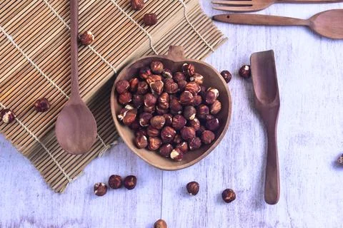 Hazelnut kernel inside wooden bowl on the side of sushi roller with wooden .. Stock Photos