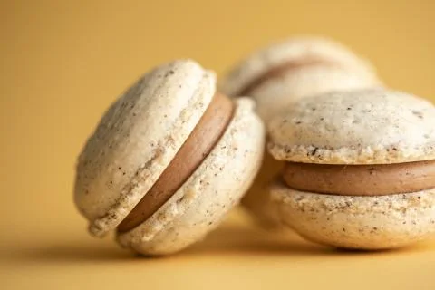 Hazelnut macarons close-up on a yellow background Stock Photos