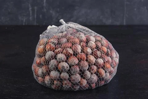 Hazelnut net rests on black background Stock Photos