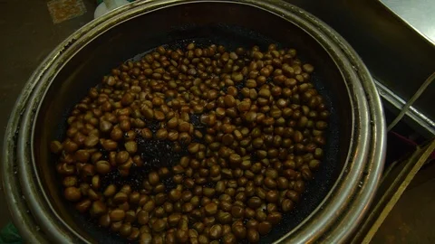 Hazelnut nuts are roasted in frying machine. Spinning around. Stock Footage 96771123