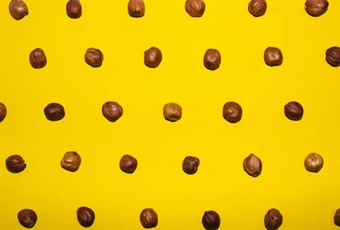 Hazelnut pattern on a yellow background, top view 스톡 사진