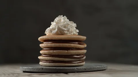 Hazelnuts and blackberries falling onto stack of pancakes in slow motion.  Shot 스톡 동영상 130351471