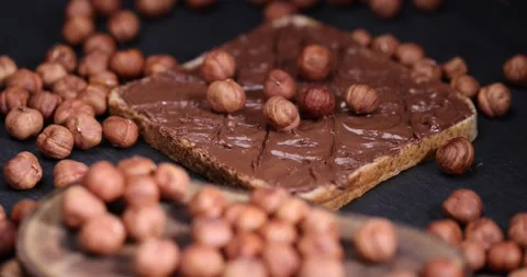 Hazelnuts and bread with nut paste with chocolate, delicious and sweet chocolate Stock Footage 293060649