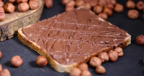 Hazelnuts and bread with nut paste with chocolate, delicious and sweet chocolate Stock Footage 293440943