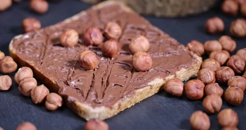 Hazelnuts and bread with nut paste with chocolate, delicious and sweet chocolate Stock Footage 293764565