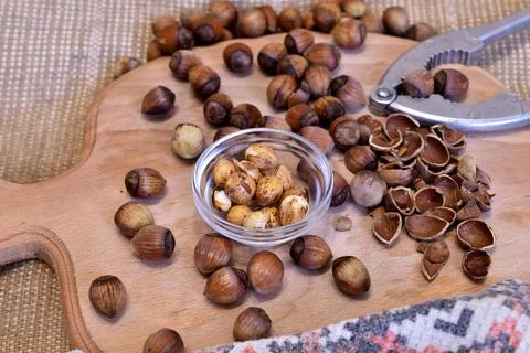 Hazelnuts and a nutcracker lie on the table. Stock Photos