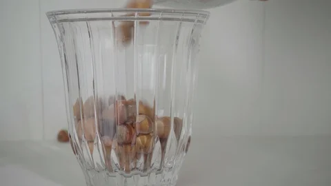 Hazelnuts are tilted into a glass storage Stock Footage 119604271