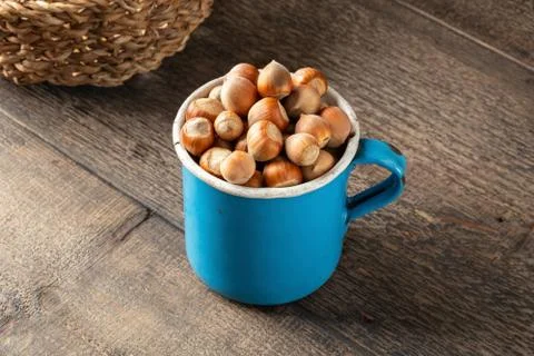 Hazelnuts in a blue pot on a table Stock Photos