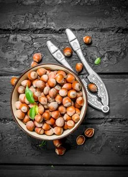 Hazelnuts in a bowl with a Nutcracker. Stock Photos