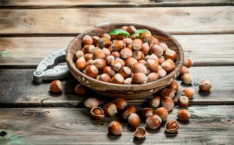 Hazelnuts in a bowl with a Nutcracker. Stock Photos