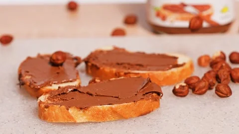 Hazelnuts chocolate spread on bread Stock Footage 272475774