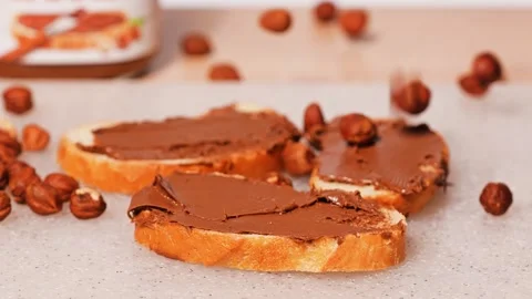 Hazelnuts chocolate spread on bread Stock Footage 272475775