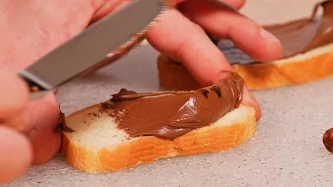Hazelnuts chocolate spread on bread Stock Footage 272475776