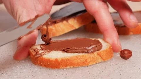 Hazelnuts chocolate spread on bread Stock Footage 272475778