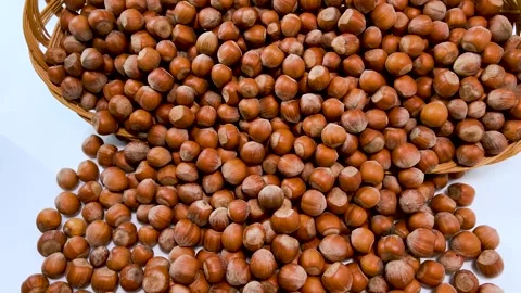 Hazelnuts come out of  wicker basket on white background Stock Footage 274011089