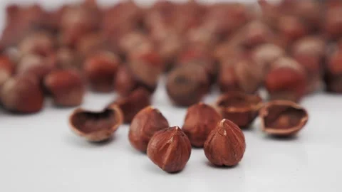 Hazelnuts in the depth of field of the inner material and shells of broken nuts Stock Footage 130972359