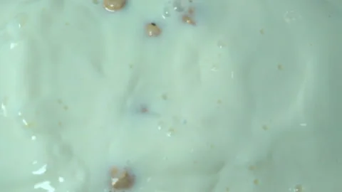 Hazelnuts fall into milk in slow motion. Video stock 133394849