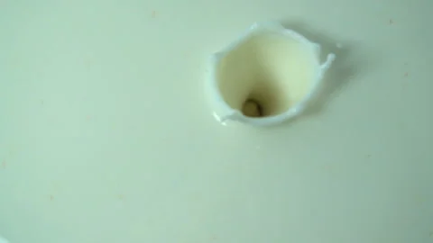 Hazelnuts fall in slow motion into milk Stock Footage 129775304