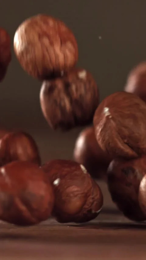 Hazelnuts fall on a wooden table. Filmed on a high-speed camera at 1000 fps Stock Footage 335373293