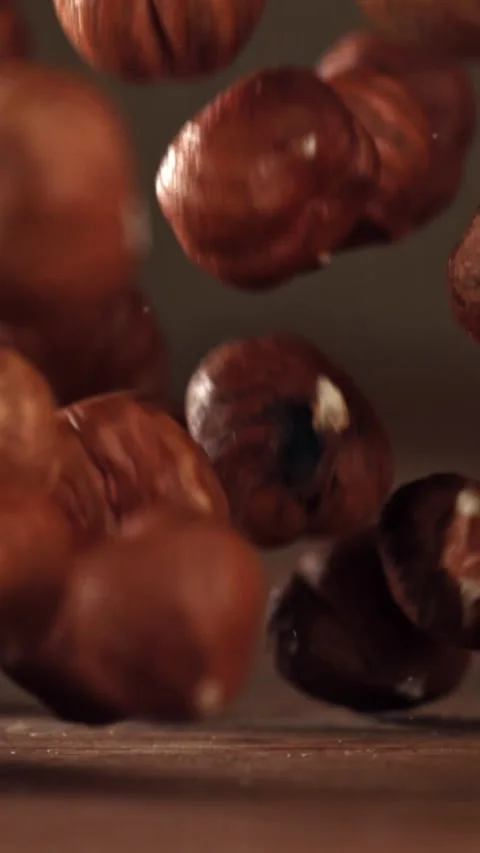 Hazelnuts fall on a wooden table. Filmed on a high-speed camera at 1000 fps Stock Footage 335373640