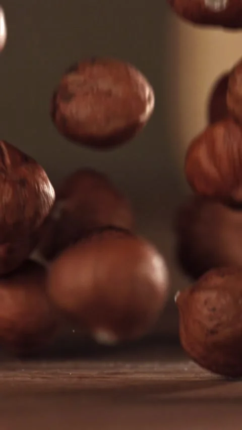 Hazelnuts fall on a wooden table. Filmed on a high-speed camera at 1000 fps Stock Footage 335374983