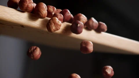 Hazelnuts falling from a cutting table in slow motion Stock Footage 152383305