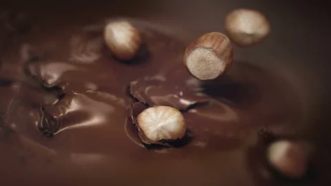 Hazelnuts Falling Into Liquid Chocolate in 4K Super slow motion Stock Footage 139144590