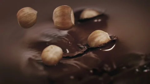 Hazelnuts Falling Into Liquid Chocolate in 4K Super slow motion Stock Footage 139144762