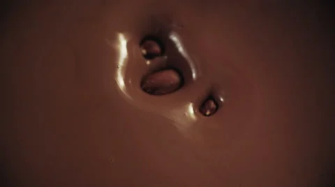Hazelnuts Falling into Melted Chocolate Stock Footage 51596409